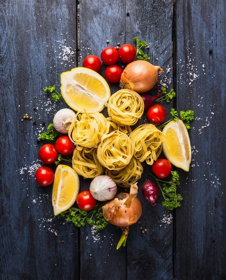 Droge deegwarentagliatelle met tomaten, kruid en kruiden voor tomatensaus, het comosing royalty-vrije stock afbeelding Droge deegwarentagliatelle met tomaten, kruid en kruiden voor tomatensaus, het comosing royalty-vrije stock afbeelding