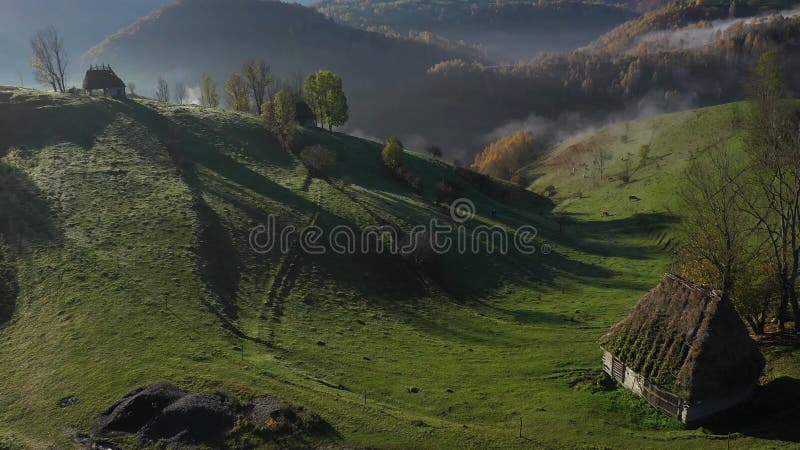 Drohblick auf eine Berghütte. Landschaftliche Nebellandschaft im Herbst mit verlassenen Häusern mit Strohdach