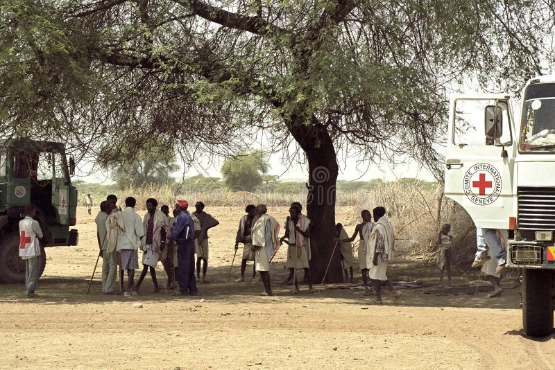 Ethiopia, Afar region: The Afar, an ethnic group of semi-nomadic cattle farmers in the vicinity of Awasch are affected by of an impending famine by drought, climate change and massive death of their livestock. Employees and trucks of the Red Cross, Comite International Geneve, arrive at a group Afar Men, in the shade of a tree, in the searing heat and dust of the Danakil desert, have been waiting for the cargo food aid, emergency aid. Due to global warming and El Nino the region is plagued by persistent drought, droughts. Ethiopia, Afar region: The Afar, an ethnic group of semi-nomadic cattle farmers in the vicinity of Awasch are affected by of an impending famine by drought, climate change and massive death of their livestock. Employees and trucks of the Red Cross, Comite International Geneve, arrive at a group Afar Men, in the shade of a tree, in the searing heat and dust of the Danakil desert, have been waiting for the cargo food aid, emergency aid. Due to global warming and El Nino the region is plagued by persistent drought, droughts.