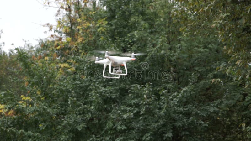 Drone with camera while flying in the forest. Unmanned aerial copter flight.