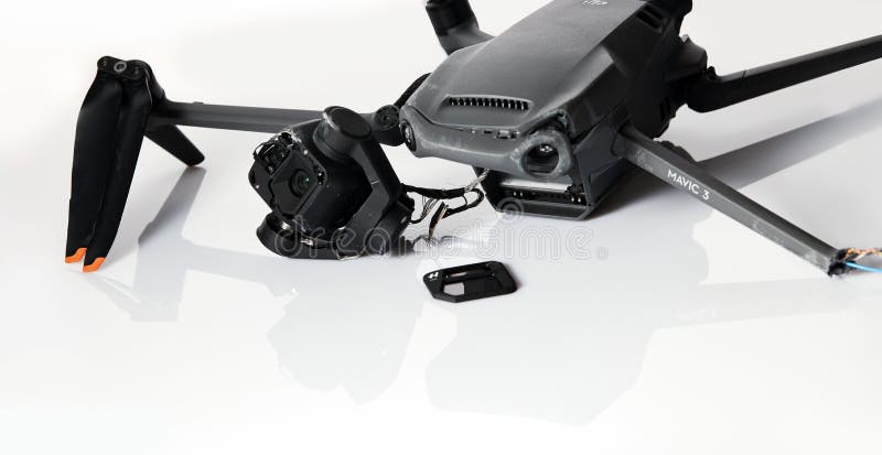 Drone DJI Mavic 3 after crashed on a white background. Drone after falling from a height. Broken gimbal camera and drone stock photography