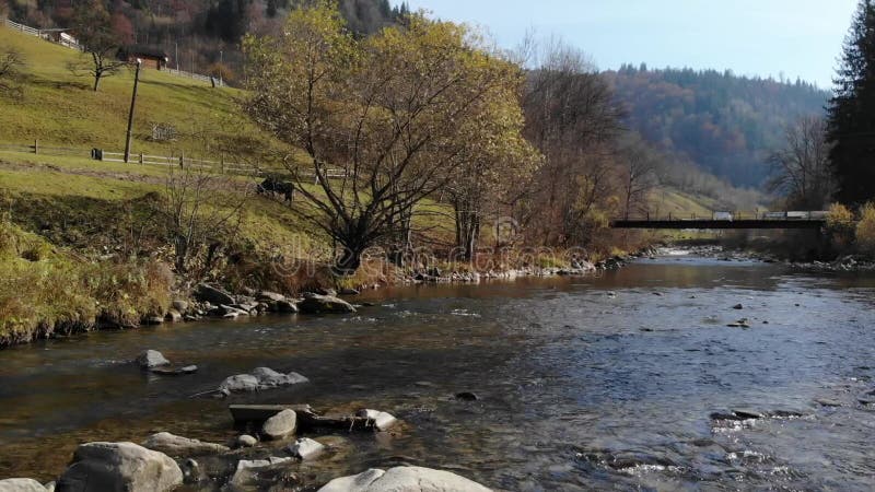 Drone que atravessa o rio da montanha até a encosta