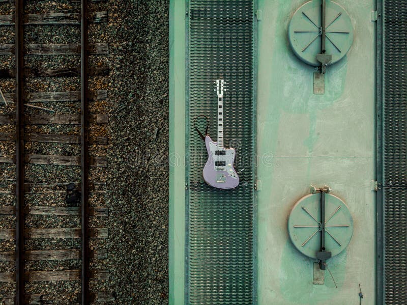 https://thumbs.dreamstime.com/b/drone-shot-aluminum-purple-electric-guitar-train-railroad-drone-shot-purple-electric-guitar-182241879.jpg