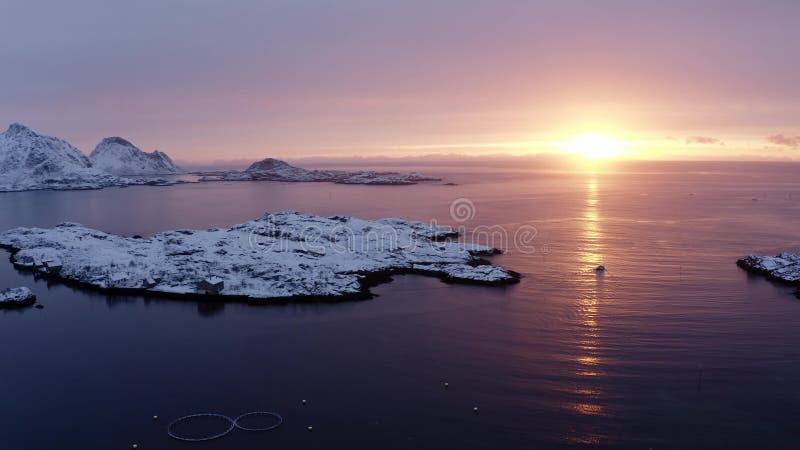 Drone sside move vídeo de embarcações de pesca navegando durante o nascer do sol nas ilhas do lofoten ártico. sol e montanhas de n