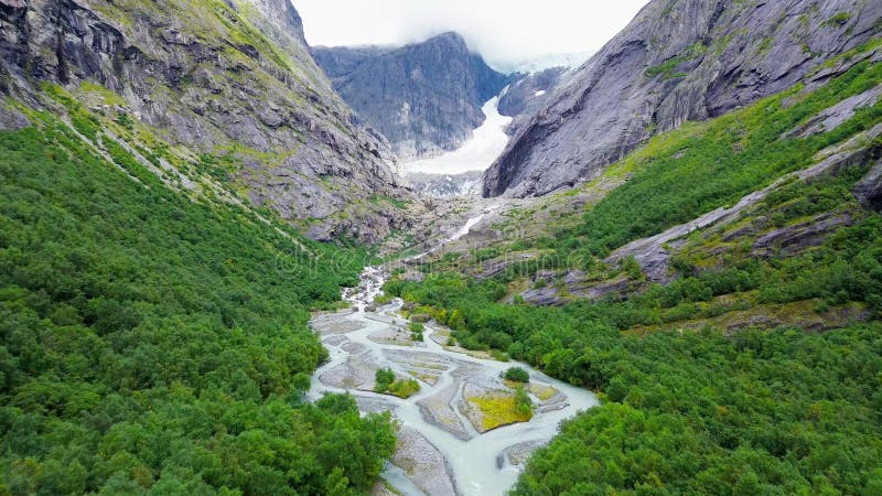 Drone view of Brenndalsbreen glacier valley in Jostedalsbreen National Park, greenery and river flow stock video footage