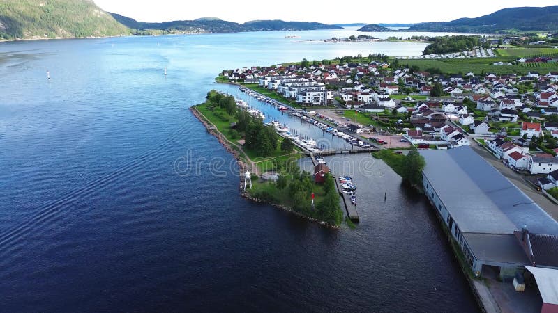Drone view of the seaside Svelvigen Brygge AS with harbor surrounded by greenery and mountains stock footage