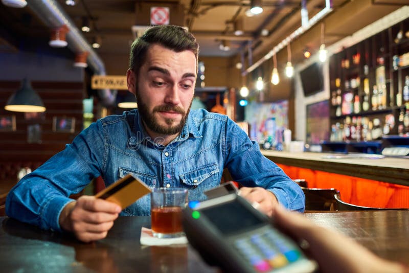 Dronken Mens die via Creditcard in Bar betalen royalty-vrije stock foto Dronken Mens die via Creditcard in Bar betalen royalty-vrije stock foto