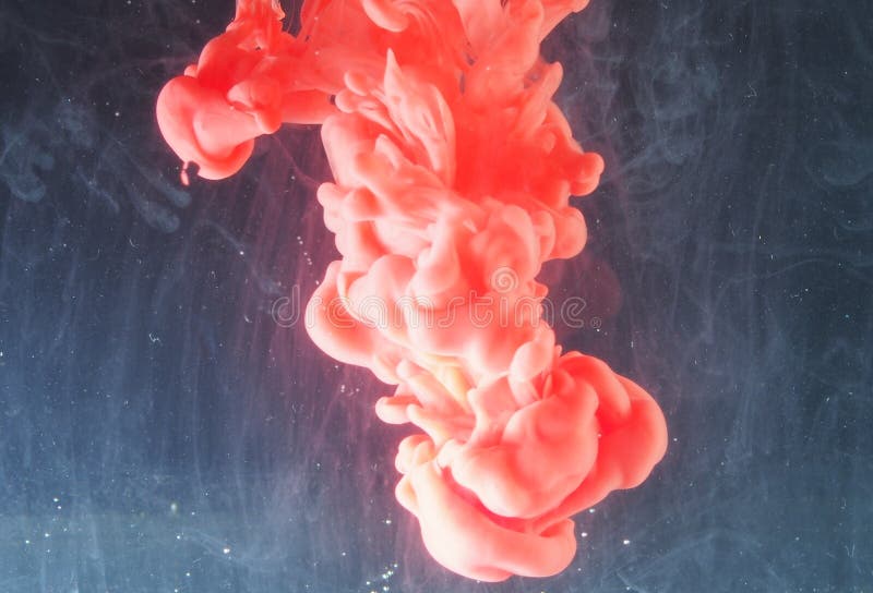 A Drop of Paint Dissolves in Water. Red Paint is Mixed with Water Stock