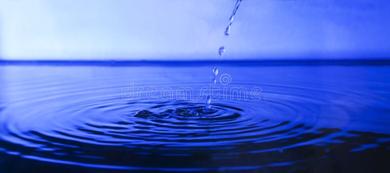 Drop water in deep blue background stock photography