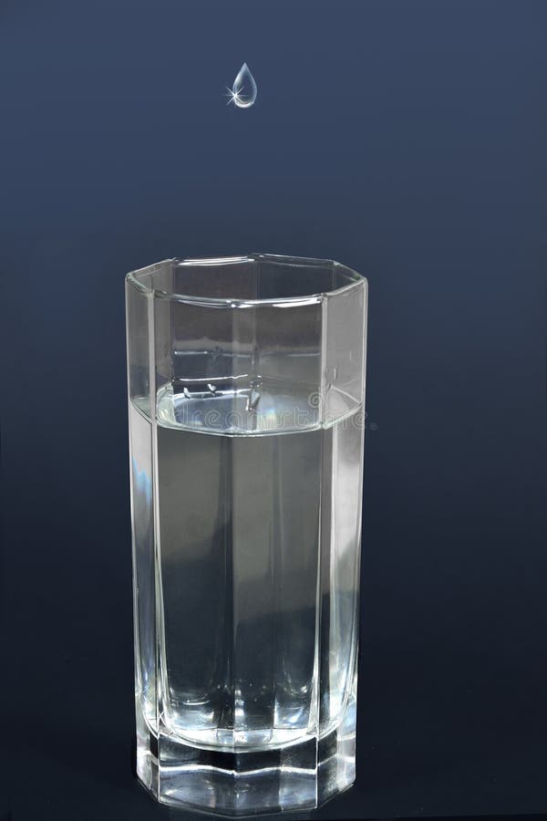 Drop of water falling into a glass filled with drink royalty free stock photos Drop of water falling into a glass filled with drink royalty free stock photos