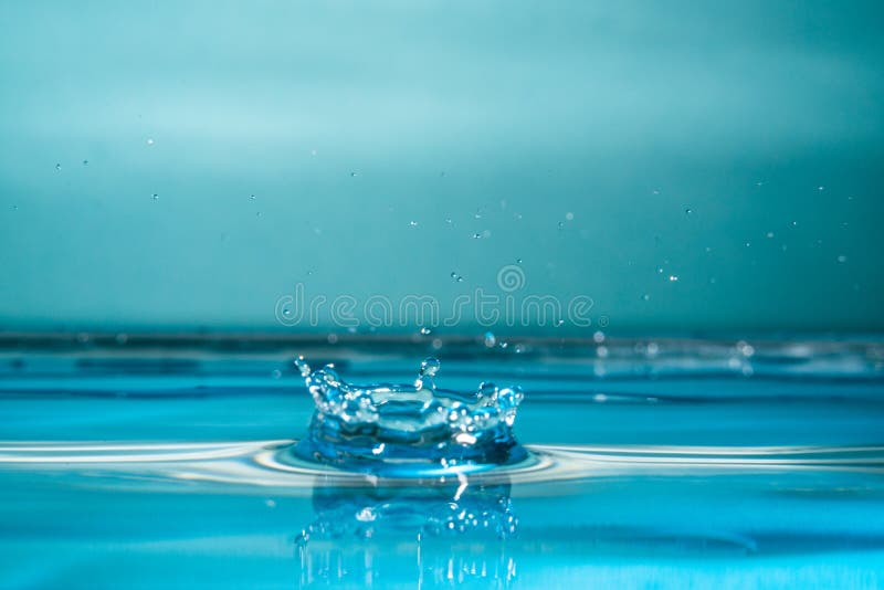 Drop of water falling into a glass, hitting water surface.Selected focus