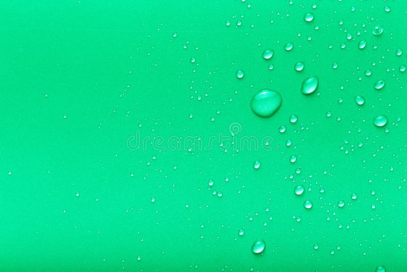 Droppar av vatten på en färgbakgrund Gräsplan tonat arkivfoto Droppar av vatten på en färgbakgrund Gräsplan tonat arkivfoto