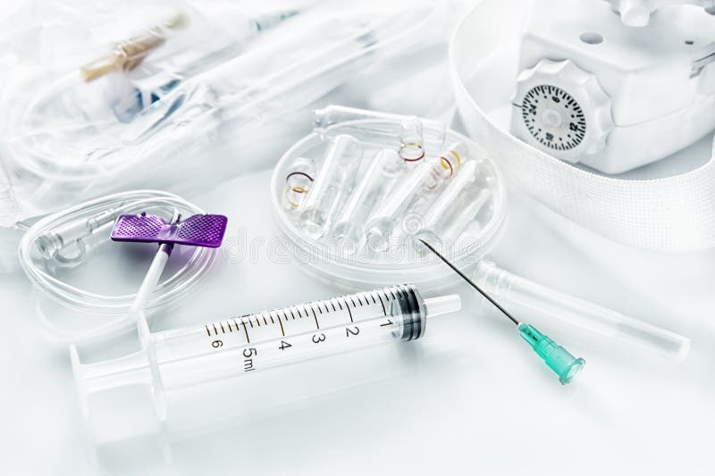 Droppglassinjektionsspruta med visaren och kateter för intravenös injektion med selet och ampuller för läkarbehandling arkivbild Droppglassinjektionsspruta med visaren och kateter för intravenös injektion med selet och ampuller för läkarbehandling arkivbild
