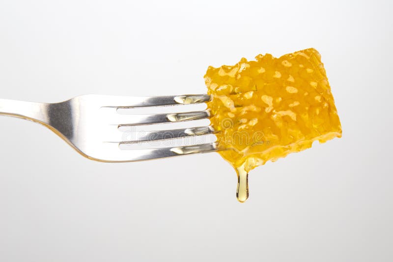 Drops of Fresh Honey Drip from Wax Honey on a Table Fork. Vitamin