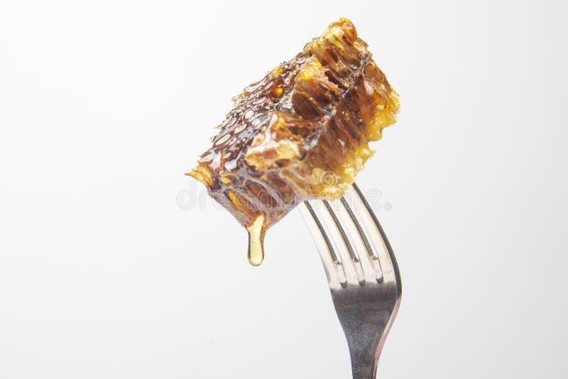 Drops of Fresh Honey Drip from Wax Honey on a Table Fork. Vitamin
