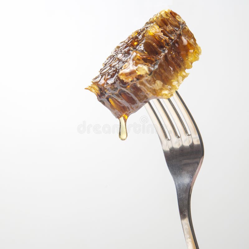 Drops of Fresh Honey Drip from Wax Honey on a Table Fork. Vitamin