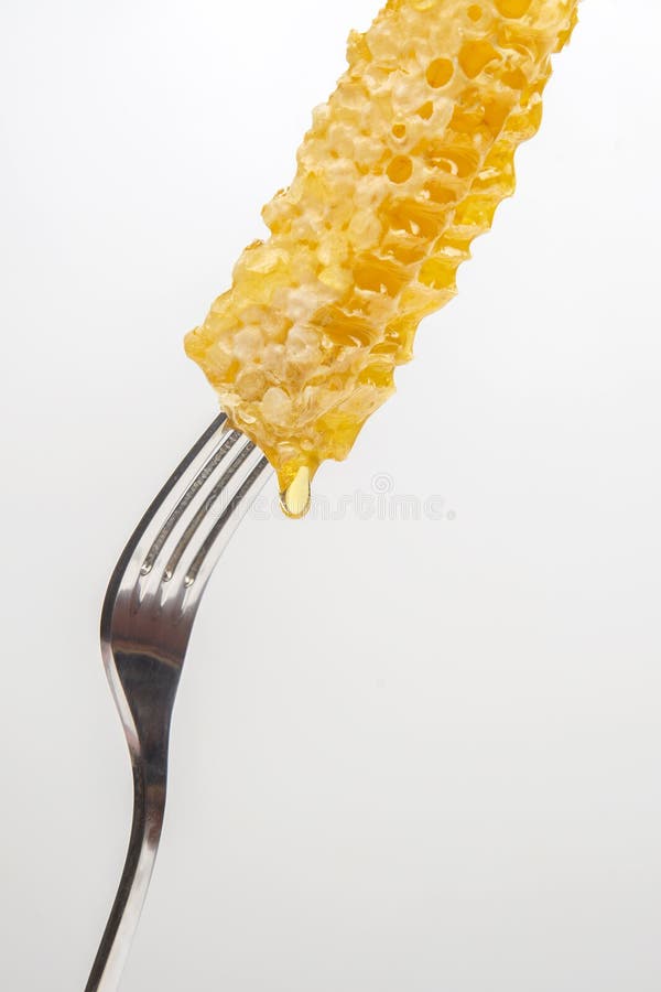 Drops of Fresh Honey Drip from Wax Honey on a Table Fork. Vitamin