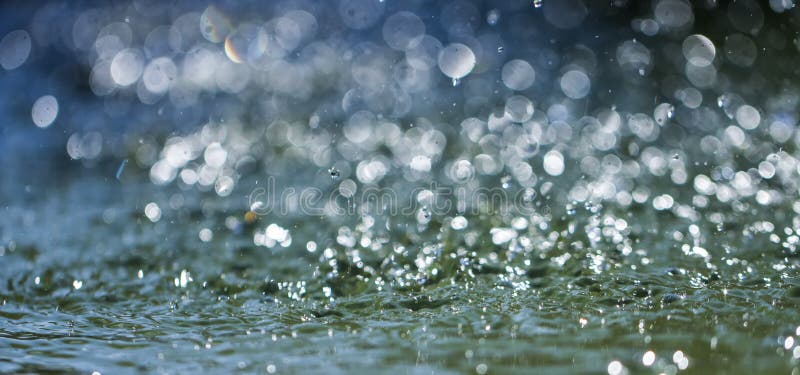 Drops of rain fall into the water, selective focus close up