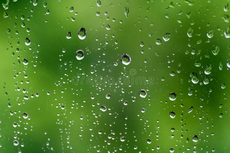 Drops of rain on a window, green background