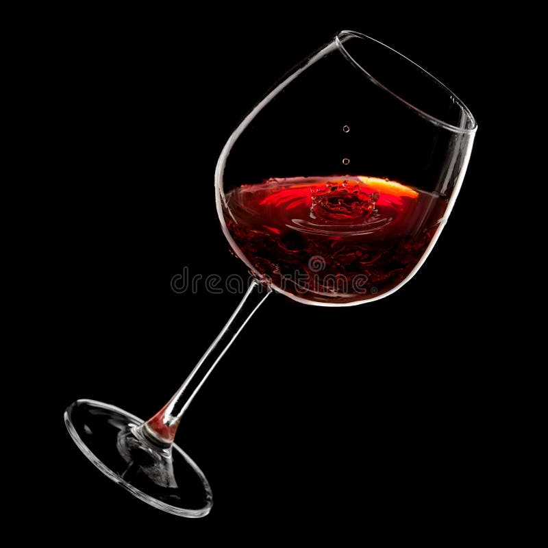 Drops of red wine dripping into a glass