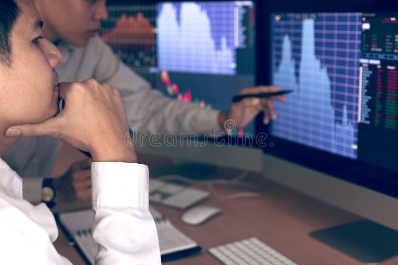 Druck mit zwei Geschäftsbörsenmaklern und Betrachten von den Monitoren, die Finanzinformationen anzeigen stockbilder Druck mit zwei Geschäftsbörsenmaklern und Betrachten von den Monitoren, die Finanzinformationen anzeigen stockbilder