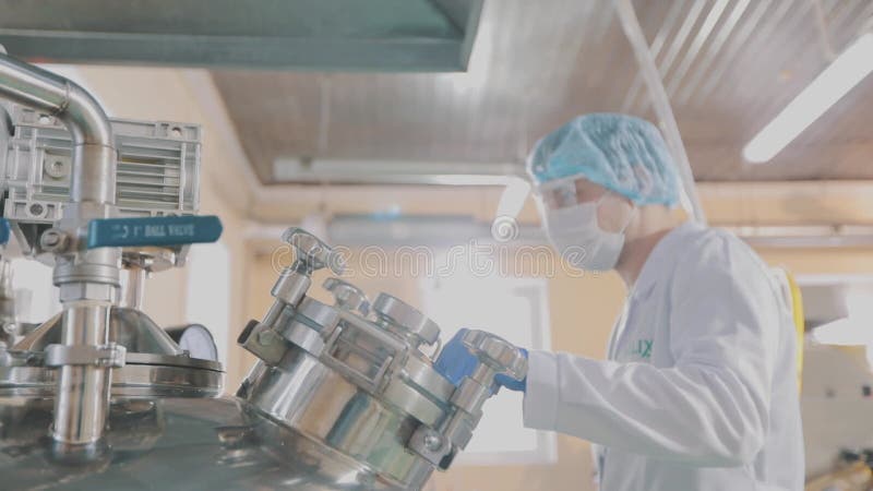Masked people work in a factory. Drug manufacturing process. Inside the pill workshop. The interior of the stock video