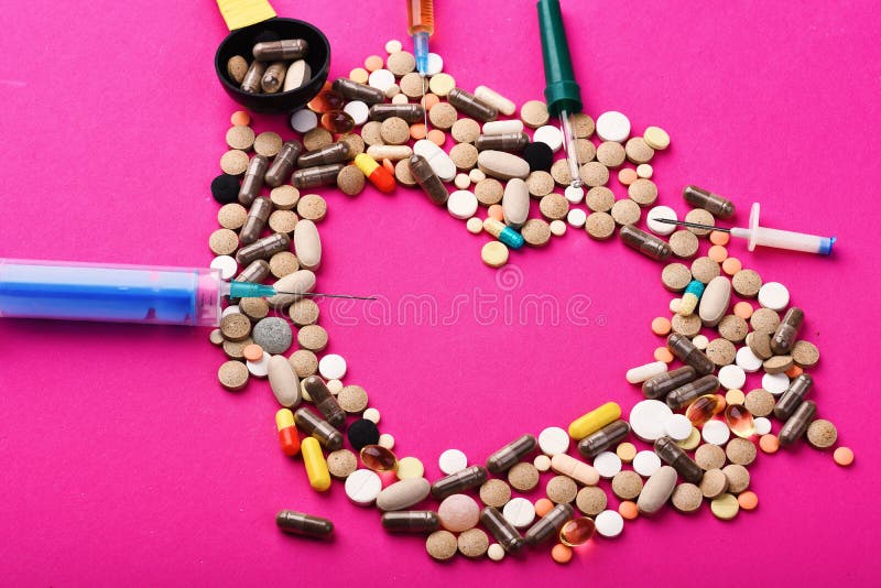 Drugs near syringes, pipette and measuring spoon. Set of colorful pills scattered on pink background, copy space. Frame made of pills and capsules put in shape of heart. Medicine and love concept. Drugs near syringes, pipette and measuring spoon. Set of colorful pills scattered on pink background, copy space. Frame made of pills and capsules put in shape of heart. Medicine and love concept