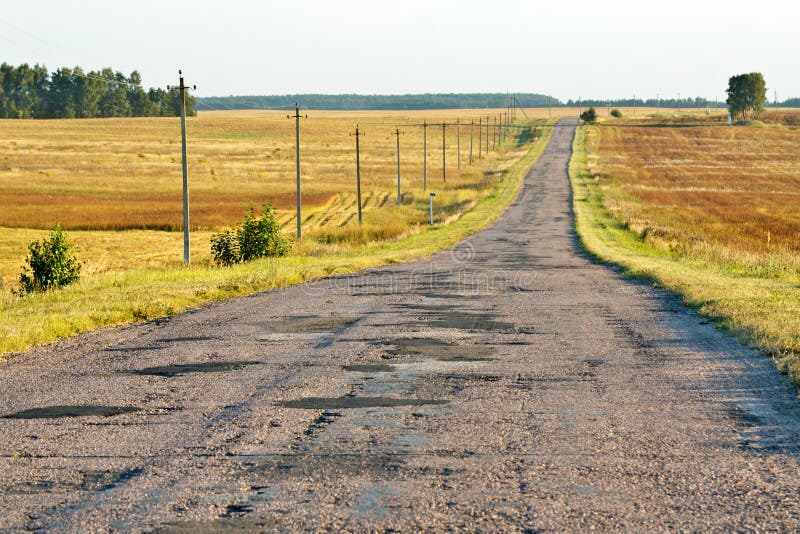 Drum pavat și ascuțit într-o zonă rurală într-o după-amiază însorită. O perspectivă asupra drumului pavat și ascuțit într-o zonă rurală, într-o după-amiază însorită