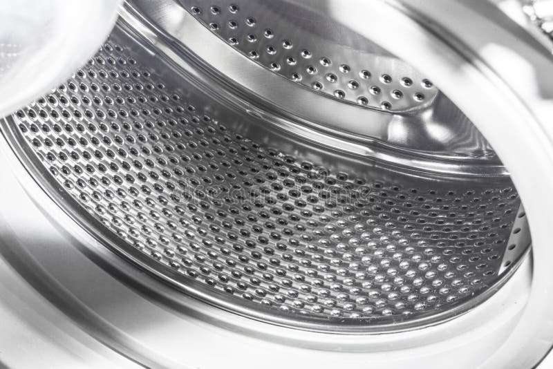 Perforated drum of an automatic washing machine sparkles in the light. Metal steel drum stock images, royalty-free photos and pictures