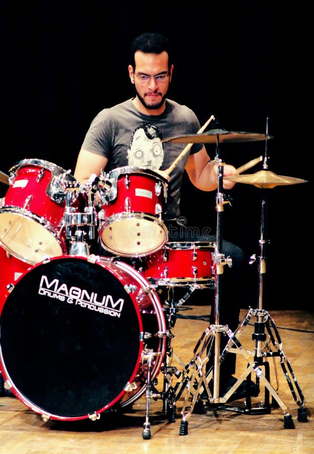 Egyptian amateur drummer playing drums with his band in a concert at the theater of the german school in cairo in egypt on may 19 , 2011