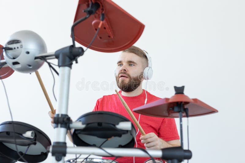 Drummer, hobbies and music concept - young man drummer in red shirt playing the electronic drums royalty free stock photo Drummer, hobbies and music concept - young man drummer in red shirt playing the electronic drums royalty free stock photo
