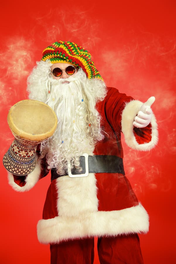 Casual Santa Claus hippie playing a drum over festive red background. Casual Santa Claus hippie playing a drum over festive red background.