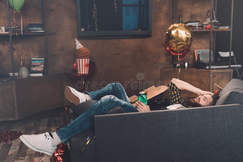 Drunk bearded young man with closed eyes lying on couch royalty free stock photos Drunk bearded young man with closed eyes lying on couch royalty free stock photos