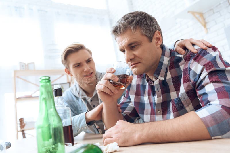 Father Drinks Alcoholic while Son Sits pic