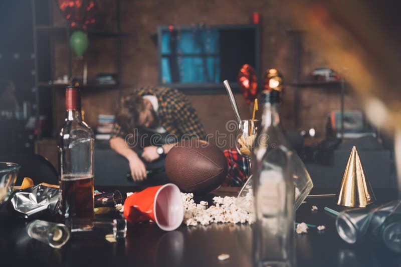 Drunk young man sleeping on couch in messy room stock images Drunk young man sleeping on couch in messy room stock images
