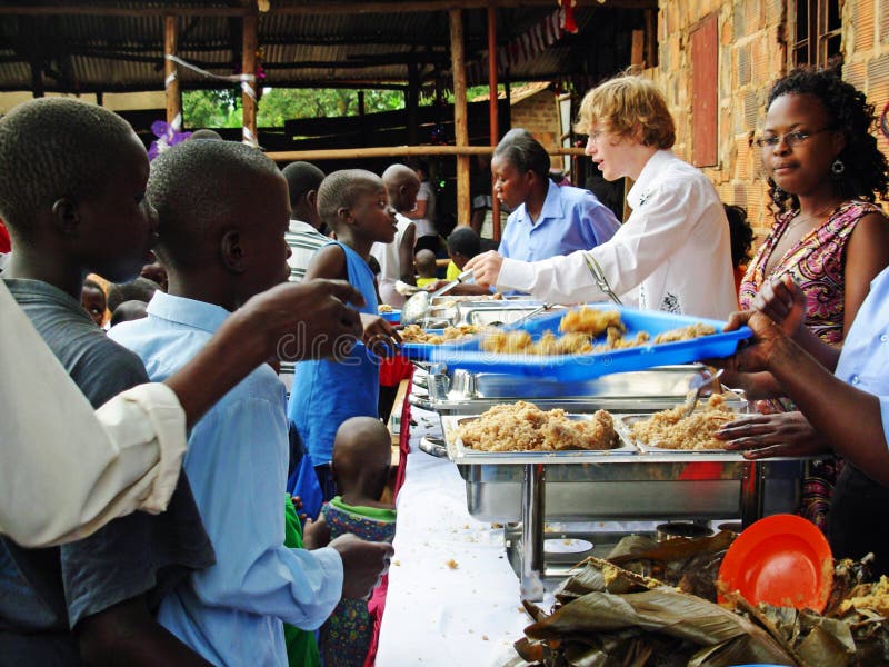 Drużynowej pomocy wolontariuszów reliefowi pracownicy karmi głodnym dzieciom Afryka