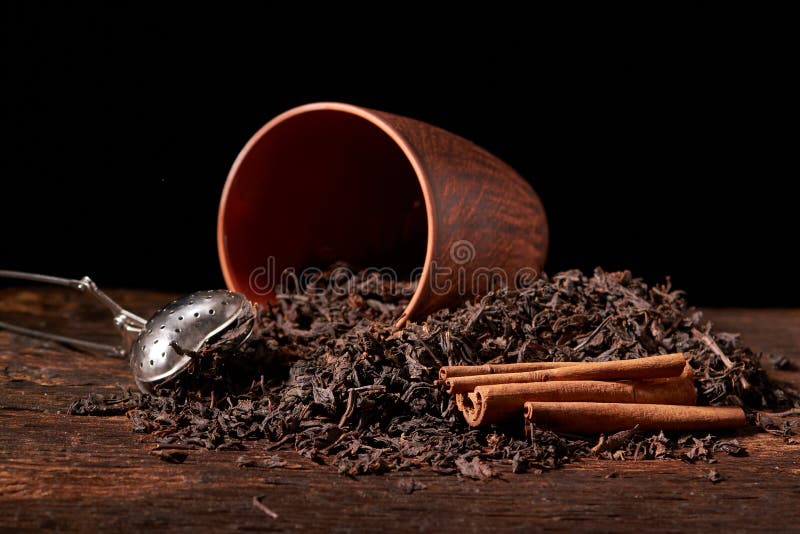 dry black chinese tea set,with strainer closeup,cups and teapot on background over old wood board stock image dry black chinese tea set,with strainer closeup,cups and teapot on background over old wood board stock image