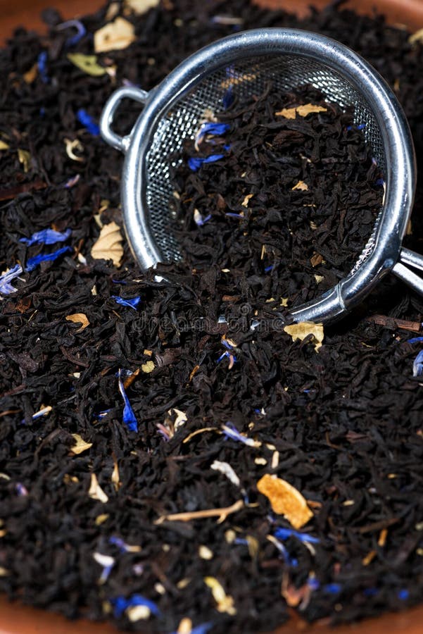 Dry Black Tea with Aromatic Herbs in a Strainer, Vertical Stock Photo