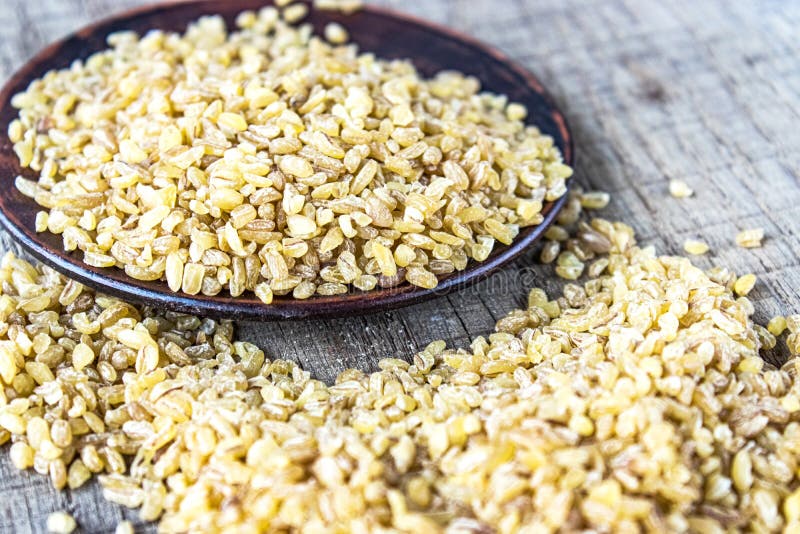 Dry bulgur grain in a bowl. A pile of raw grain Bulgur porridge. Healthy, dietary, vegan, gluten free product. Healthy eating concept. Organic product made from wheat grains. Close-up