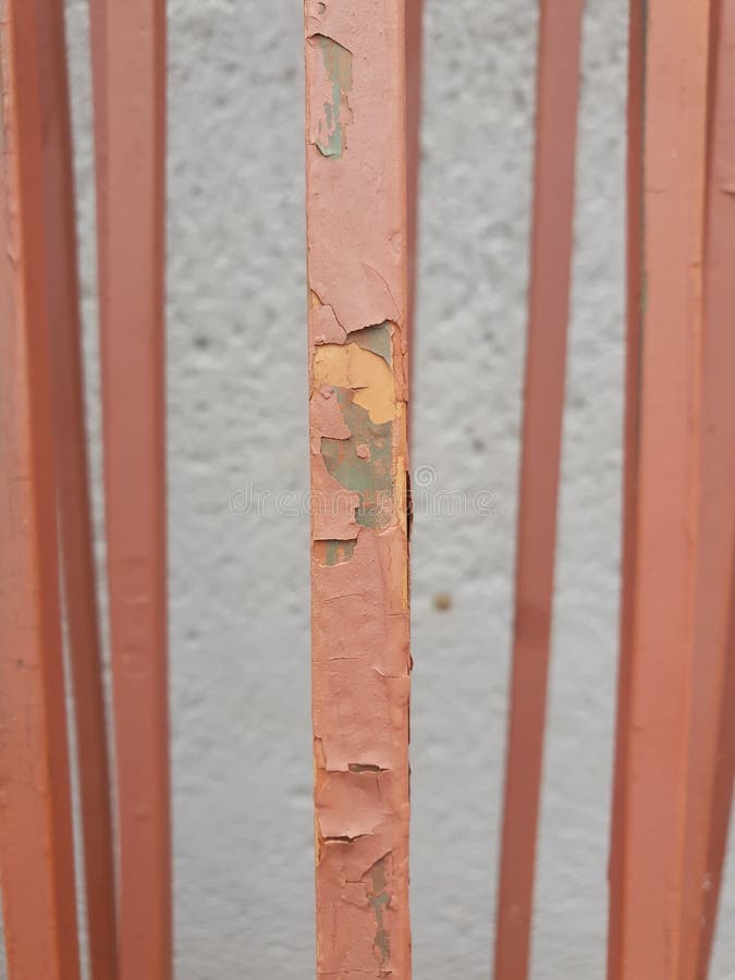 Dry Old Paint Peeling Off Metal Bars from an Old and Uninstalled Fence