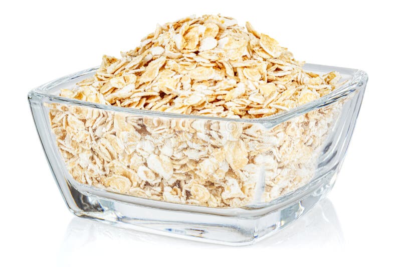Dry rolled oats in a small transparent glass square bowl isolated on white background stock photography Dry rolled oats in a small transparent glass square bowl isolated on white background stock photography