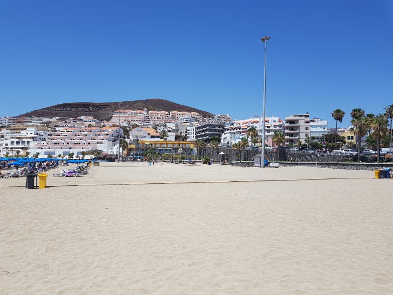 Dry sandy beach view in Playa de las Americas Tenerife with apartments in the distance