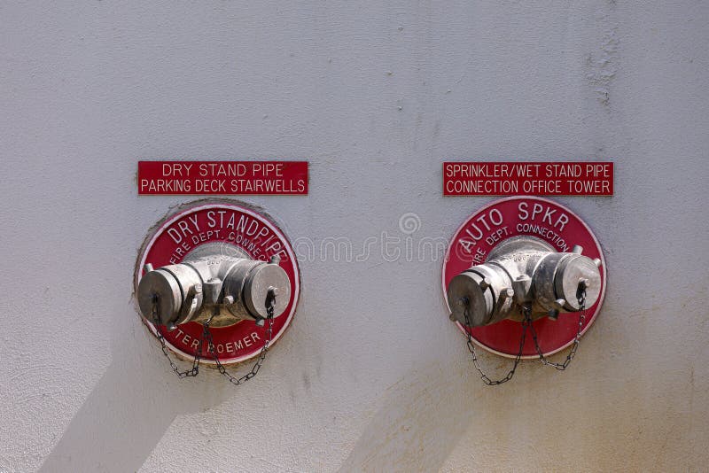 A dry standpipe and  sprinkler/wet standpipe on a grey wall