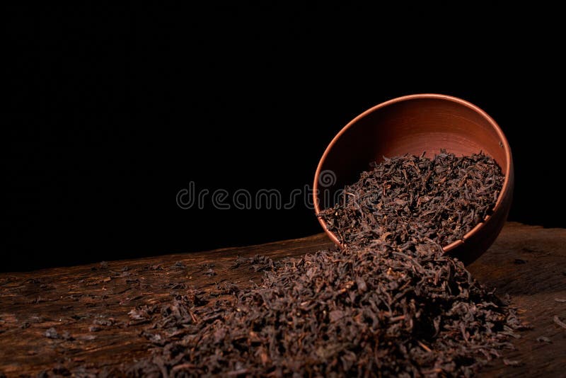 Dry tea leaves in clay bowl on black background. selective focus royalty free stock photos Dry tea leaves in clay bowl on black background. selective focus royalty free stock photos