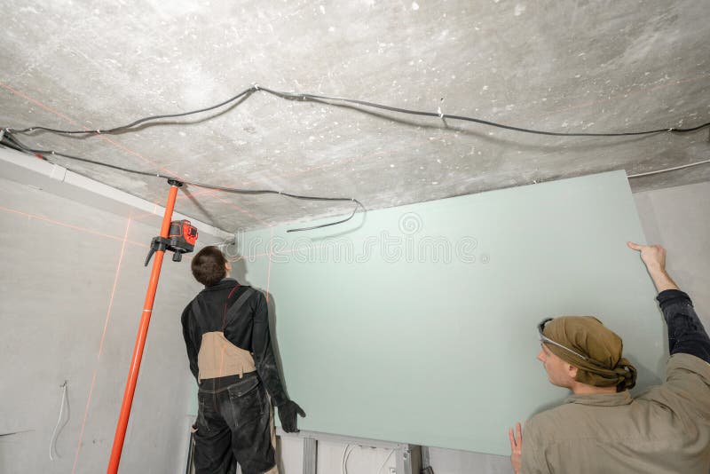 Drywallinstallation, väggjustering Laser-mätning under renovering Konstruktionshjälpmedel och utrustning Röda laser-enheter arkivfoton Drywallinstallation, väggjustering Laser-mätning under renovering Konstruktionshjälpmedel och utrustning Röda laser-enheter arkivfoton