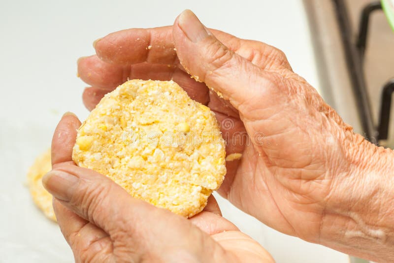 Drücken Sie die Teigbälle flach, um die arepa typische Form zu bilden lizenzfreies stockfoto Drücken Sie die Teigbälle flach, um die arepa typische Form zu bilden lizenzfreies stockfoto
