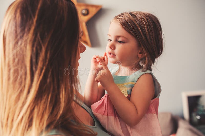 Drăguță fetiță care se joacă cu mama acasă stock images