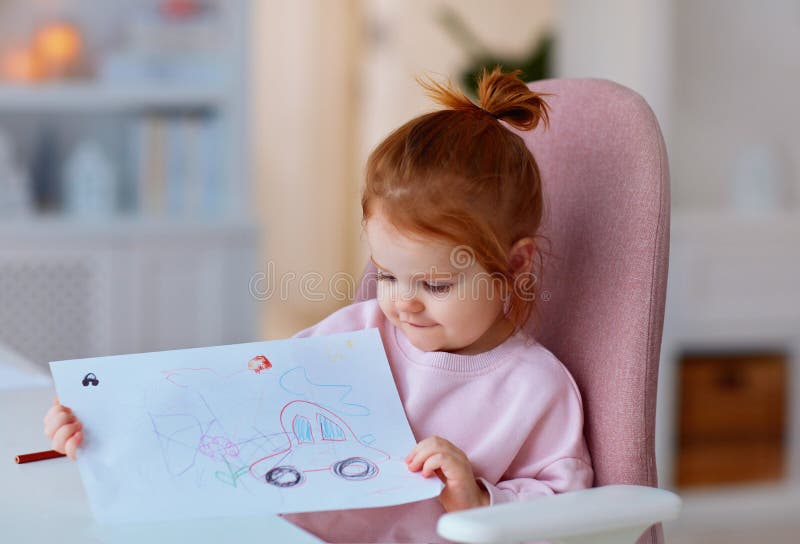 Drăguță fetiță care își arată desenul făcut cu creioane colorate stock photos