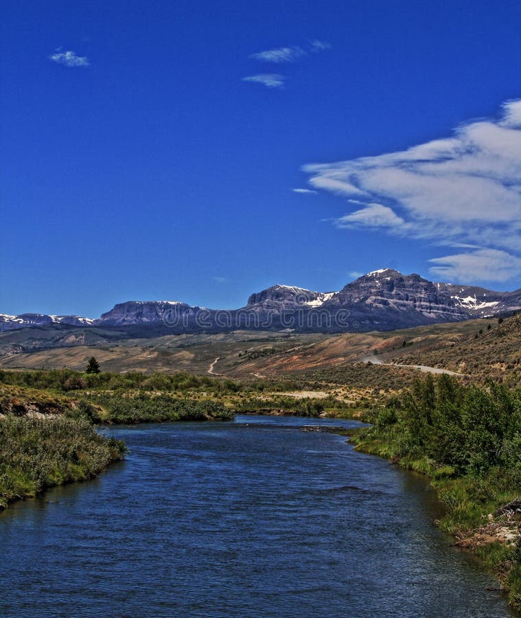 Du Noir Creek just outside of Dubois Wyoming with Breccia Cliffs and Breccia Peak in the background on Togwotee Pass Absaroka Mountains during the summer in Wyoming USA with wispy clouds over head. This is the mountain pass between Dubois Wyoming and the Grand Tetons National Park / Jackson Hole (valley) where the Absaroka and Wind River mountain ranges of the Rockies meet. Du Noir Creek just outside of Dubois Wyoming with Breccia Cliffs and Breccia Peak in the background on Togwotee Pass Absaroka Mountains during the summer in Wyoming USA with wispy clouds over head. This is the mountain pass between Dubois Wyoming and the Grand Tetons National Park / Jackson Hole (valley) where the Absaroka and Wind River mountain ranges of the Rockies meet