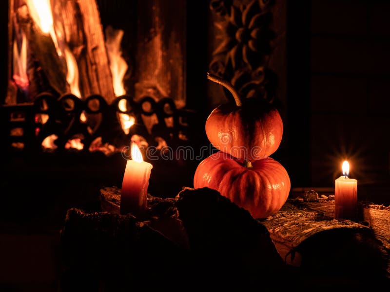 Duas abóboras de Halloween no escuro em torres de pássaros queimando velas No fundo há uma chama de uma lareira fotos de stock Duas abóboras de Halloween no escuro em torres de pássaros queimando velas No fundo há uma chama de uma lareira fotos de stock